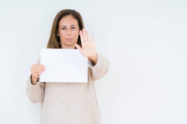 Boş kağıt sayfası ile izole arka plan üzerinde tutan orta yaş kadın dur işareti ile ciddi ve kendine güvenen ifade, savunma hareketi yaparken el açmak