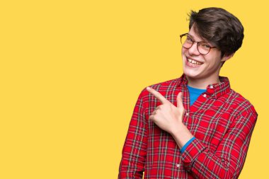 İzole arka neşeli bir gülümseme ile el ve parmak kadar yan yüzünde mutlu ve doğal ifade ile işaret yüz üzerinden gözlüklü genç yakışıklı adam