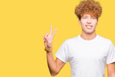 Gösterilen ve parmakları ile işaret casual beyaz t-shirt giyen afro saçlı yakışıklı delikanlı ikincisi ise kendinden emin ve mutlu gülümseyerek.