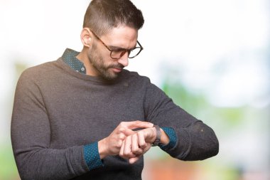 Kol saati, rahat ve kendinden emin zamanında kontrol izole arka plan üzerinde gözlük takan genç yakışıklı adam