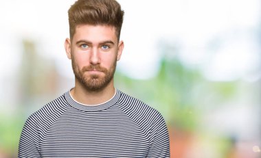 Çizgili süveter giyen genç yakışıklı adam depresif ve kızgın ve korkmuş ağlıyor sıkıntı için endişeleniyorum. Üzgün ifade.