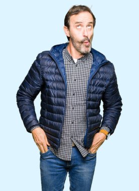 Orta yaş yakışıklı adam giyen kış ceket dudaklı, çılgın ve komik bir jest yapma balık yüz. Komik ifade.