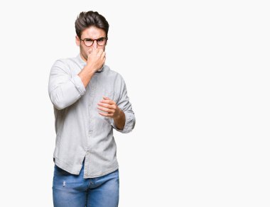 Gözlük takan bir şey pis ve iğrenç kokulu izole arka plan, dayanılmaz koku, holding nefes burun parmaklar ile yakışıklı delikanlı. Kötü kokuyor kavramı.