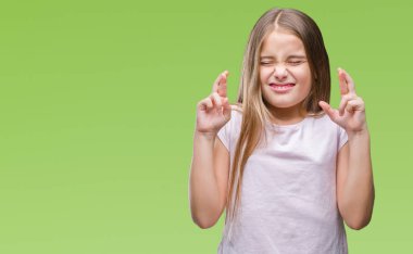 Genç güzel kız umut ve gözleri kapalı geçiş parmaklarıyla gülümseyen izole arka plan yüzünden. Şans ve batıl kavramı.