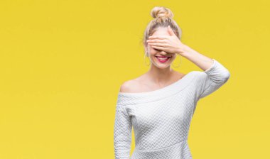 Genç güzel sarışın ve mavi gözlü kadın gülümsüyor ve gözleri için sürpriz kapsayan yüz el ile gülüyor izole arka plan yüzünden. Kör kavramı.