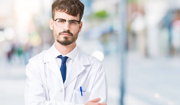 年轻的专业科学家男子穿着白色外套在孤立的背景怀疑和紧张 不赞成的表情在脸上交叉的武器 消极的人 — 图库照片