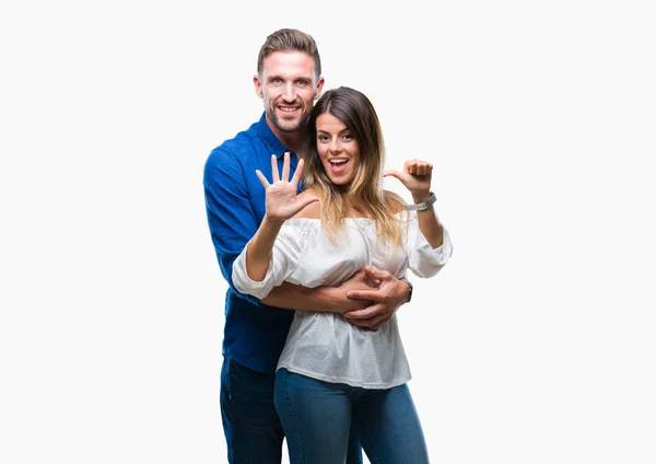 年轻夫妇在爱在孤立的背景显示和指向与手指数字六同时微笑自信和快乐 — 图库照片