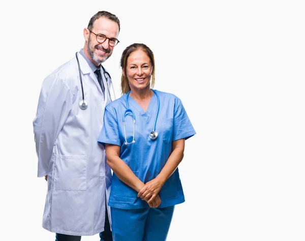 中年西班牙医生的伴侣夫妇穿着医疗制服在孤立的背景与一个快乐和冷静的笑容在脸上 幸运的人 — 图库照片