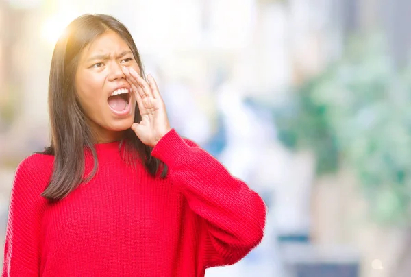 年轻的亚洲妇女穿着冬季毛衣在孤立的背景下 大声尖叫 并与手在嘴上大叫 沟通理念 — 图库照片