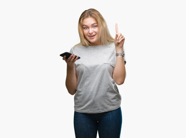 年轻的白种人妇女发送消息使用智能手机在孤立的背景惊讶的想法或问题指向手指与幸福的脸 — 图库照片