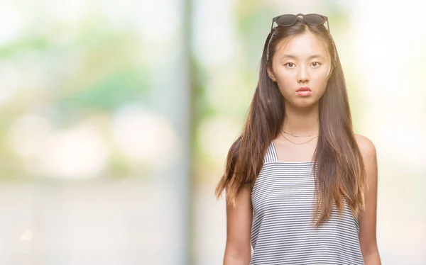 Junge Asiatin Mit Sonnenbrille Über Isoliertem Hintergrund Mit Ernstem Gesichtsausdruck — Stockfoto