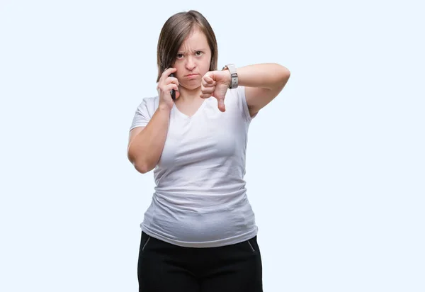 スマート フォンを使った撮影ダウン症若い成人女性分離怒った顔 ダウン親指で嫌悪感を示すマイナス記号 拒絶反応の概念と背景 — ストック写真