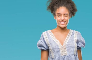 Genç afro Amerikalı kadın seksi bir ifadeyle, neşeli ve mutlu yüzünü kameraya bakarak göz kırpıyor izole arka plan üzerinde.