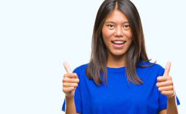 Genç Asyalı kadın el ile pozitif jest yapıyor izole arka plan başarı işareti üzerinde başparmak gülümseyen ve mutlu. Neşeli bir ifadeyle, kazanan jest kameraya bakıyor.