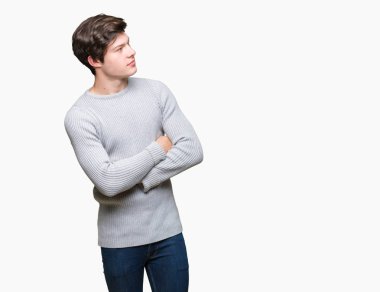 İkna ve kendine güvenen tarafına silahlarla seyir gülümseyen izole arka plan üzerinde kış kazak giyen genç yakışıklı adam geçti