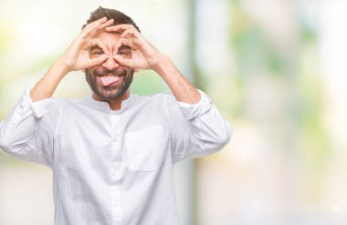 Dilini, parmaklarının arasından baktığını yapışmasını dürbün gibi ok jest yapıyor izole arka plan yetişkin İspanyol adam. Deli ifade.