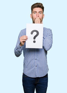 Yakışıklı delikanlı elle hata, korku, ifade için utanç ile şok soru işareti kapak ağzınla kağıt tutan sessizlik içinde gizli kavramı korkuttu