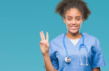 Genç afro Amerikalı doktor kadın gösterilen ve parmakları ile işaret izole arka plan yüzünden kendinden emin ve mutlu gülümseyerek iken üçüncü.