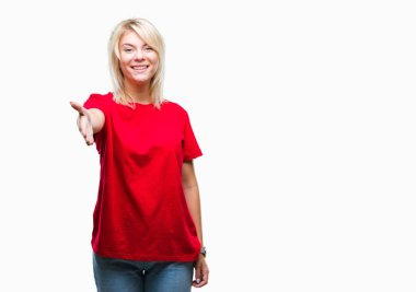 Tebrik ve konuksever dost sunan karşılıklı gülümseyen izole arka plan üzerinde kırmızı t-shirt giyen genç güzel sarışın bir kadın. Başarılı iş.