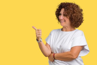 Yanına bir jest yapıyorsun gülümseyen gurur, seyir izole arka plan üzerinde beyaz t-shirt giyen güzel orta ager kadın kıdemli yaşasın