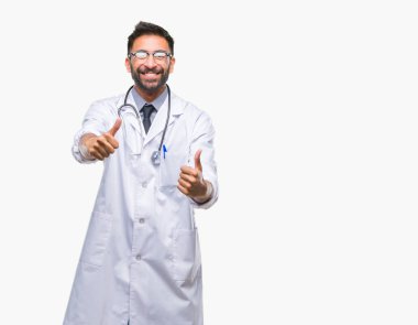 İzole arka plan onaylama üzerinde yetişkin İspanyol doktor adam el ile pozitif jest yapıyor gülümseyen ve başarı için mutlu yaşasın. Kamera, kazanan jest arıyorsunuz.