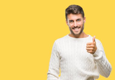 Hareketi el ile mutlu yaşasın yapıyor izole arka plan üzerinde kış kazak giyen genç yakışıklı adam. Kameraya bakarak başarı gösteren ile ifade onaylama.