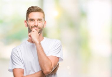 Yakışıklı delikanlı emin çapraz kollar ve çeneme kaldırdı el ile gülümseme ile kameraya bakarak izole arka plan üzerinde. Pozitif düşünce.