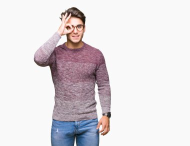 Gülümseyen, parmakları ile mutlu yüz üzerinden seyir göz el ile ok jest yapıyor izole arka plan üzerinde gözlük takan genç yakışıklı adam.