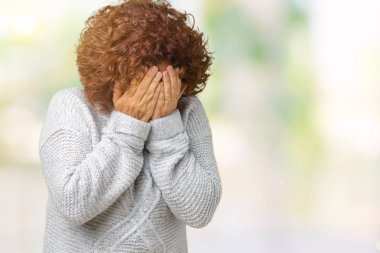 Yüzünü elleriyle ağlayarak süre kapsayan üzgün ifade ile izole arka plan üzerinde kış kazak giyen güzel orta ager üst düzey kadın. Depresyon kavramı.