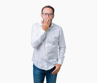 Yakışıklı orta yaş esneme izole arka plan üzerinde gözlüklü zarif üst düzey iş adamı sıkılmış kapsayan ağız el ile yorgun. Restless ve uyku hali.