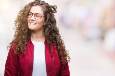 Ceket ve gözlük görünümlü yan ve dik dik bakma uzağa düşünce gülümseyen izole arka plan üzerinde giyen güzel esmer kıvırcık saçlı Genç kız.