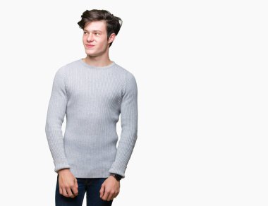 Görünümlü yan ve dik dik bakma uzağa düşünce gülümseyen izole arka plan üzerinde kış kazak giyen genç yakışıklı adam.