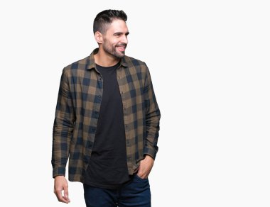 Yakışıklı delikanlı uzak tarafına yüzünde, doğal ifade gülümseme ile seyir izole arka plan üzerinde. Kendine güvenen gülüyor.