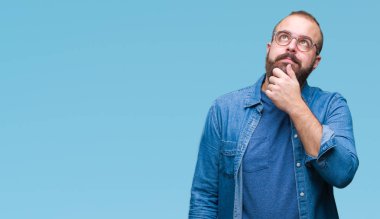 Çene düşünme hakkında soru, dalgın ifade üzerine el ile izole arka plan üzerinde gözlük takan Genç beyaz hipster adam. Düşünceli yüzüyle gülümsüyor. Şüphe kavramı.