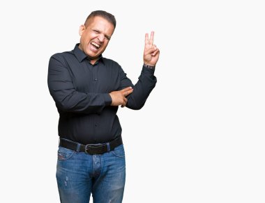 Yakışıklı orta yaş Arap iş adamı mutlu yüz zafer işareti yaparken kameraya göz kırpıyor ile gülümseyen izole arka plan üzerinde. İki numaralı.