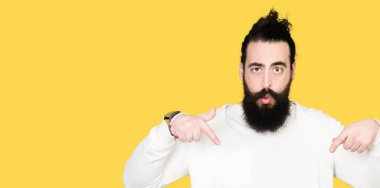 Uzun saç ve sakal sportif sweatshirt giyen genç hipster adamla aşağı reklam, sürpriz yüz ve açık ağız gösterilen parmakları ile işaret