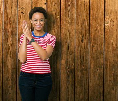 Güzel genç Afro-Amerikan kadın gözlük izole üzerinde arka plan Clapping ve mutlu ve neşeli, gururlu gülümseyen birlikte eller alkış