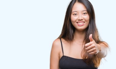 Genç Asyalı kadın hareketi el ile mutlu yaşasın yapıyor izole arka plan üzerinde. Kameraya bakarak başarı gösteren ile ifade onaylama.