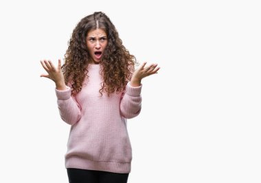 Güzel esmer kıvırcık saçlı Genç kız izole arka plan çılgın ve kızgın bağırarak ve agresif ifade ve silah kaldırdı bağırmaya üzerinde pembe kış kazak giyiyor. Hayal kırıklığı kavramı.