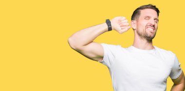 Yakışıklı adam geri, germe casual beyaz t-shirt giyen yorgun ve rahat, Uykulu ve erken sabah esneme