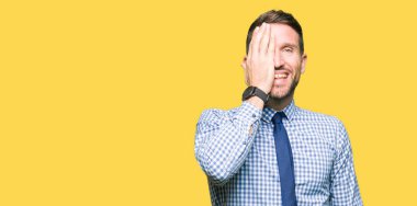 El yüz ve sürpriz duygu kendinden emin gülümseme ile tek gözüyle kapsayan kravat takan yakışıklı iş adamı.