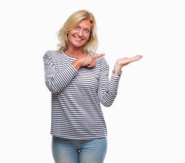 Orta yaş sarışın kadın üzerinden hayran ve el ile sunulması ve parmak ile işaret ederken kameraya gülümseyen izole arka plan.