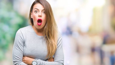 Genç güzel işçi iş kadını izole arka plan korkuyor ve şok sürpriz ifade, korku ve heyecan yüz üzerinden.