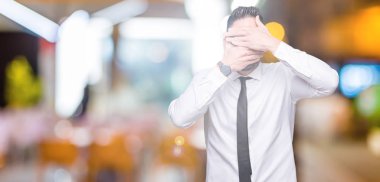 Genç yakışıklı iş adamı izole arka plan kaplaması gözler ve ağız el ile üzerinden gözlük takan şaşırttı ve şok. Duygu gizleme