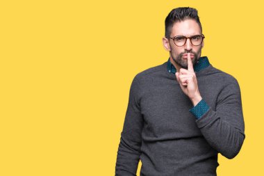 Dudaklarında parmak ile sessiz olmanı izole arka plan üzerinde gözlük takan yakışıklı delikanlı. Sessizlik ve gizli kavramı.