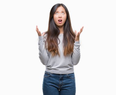 Genç Asyalı kadın izole arka plan çılgın ve kızgın bağırarak ve agresif ifade ve silah kaldırdı bağırıyor. Hayal kırıklığı kavramı.