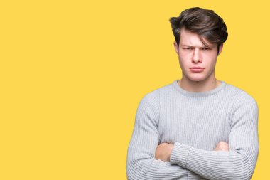 İzole arka plan şüpheci ve sinir, onaylamayan ifade yüz çapraz kolları üzerinde kış kazak giyen genç yakışıklı adam. Negatif kişi.