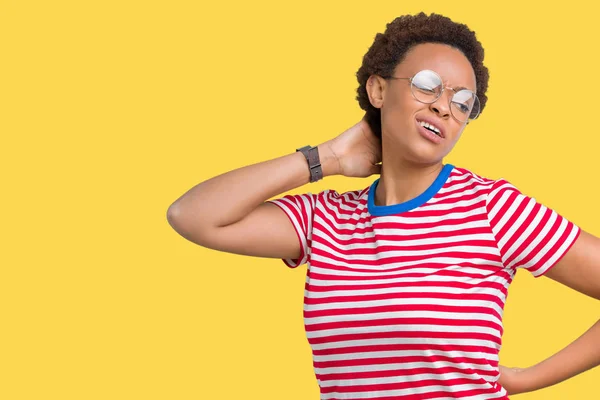 Beautiful young african american woman wearing glasses over isolated background Suffering of neck ache injury, touching neck with hand, muscular pain
