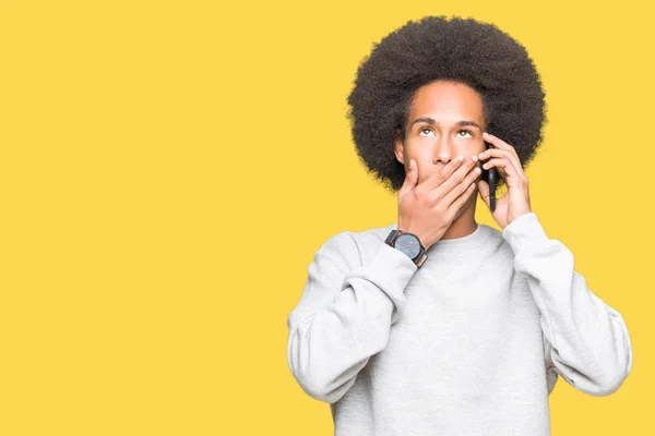 Unga Afroamerikanska Man Med Afro Hår Talar Smartphone Täcker Munnen — Stockfoto