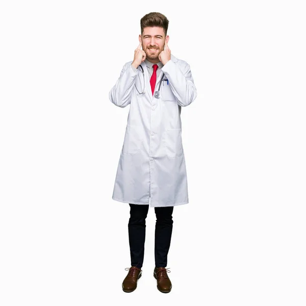 Young Handsome Doctor Man Wearing Medical Coat Covering Ears Fingers — Stock Photo, Image